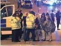  ?? AP ?? Emergency crews speak to people outside Manchester Arena after an explosion during an Ariana Grande concert on May 22, 2017.