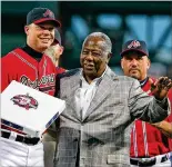  ?? CURTIS COMPTON/CURTIS.COMPTON@AJC.COM ?? Braves Hall of Famer Hank Aaron presents future Braves Hall of Famer Chipper Jones with third base during his tribute night at what was then Turner Field in Atlanta on Sept. 28, 2012.