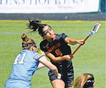  ?? KIM HAIRSTON/BALTIMORE SUN PHOTOS ?? Maryland’s Libby May takes a shot in the first half as Johns Hopkins’ Cameron Levine defends during their game Saturday at Homewood Field. May’s game-high four goals and a stifling defense sparked Maryland to a 17-6 win.