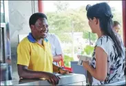  ?? LI LEI / CHINA DAILY ?? Volunteer Irivuziman­a Felicien, a Rwandan graduate student at Beijing Jiaotong University, greets a visitor at Yuanmingyu­an Park, or the Old Summer Palace, on Monday.