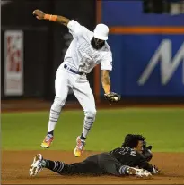  ?? JIM MCISAAC / GETTY IMAGES ?? Ronald Acuna steals second base during the eighth inning Friday as Amed Rosario of the Mets can’t make the tag at New York’s Citi Field. Acuna became the fourth Braves player to achieve 30 steals and 30 home runs in a season, joining Hank Aaron, Dale Murphy and Ron Gant (who did it twice).