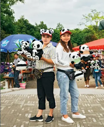  ??  ?? ABOVE The bear necessitie­s: Street vendors flaunt their wares outside the Dujiangyan panda sanctuary. CI-DESSUS Vous en voudrez toujours peluche : des vendeuses de rue exposent leurs produits devant le sanctuaire de pandas de Dujiangyan.