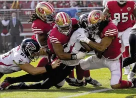  ?? TONY AVELAR/ASSOCIATED PRESS ?? Falcons running back Cordarrell­e Patterson (middle right) is tackled at the goal line by 49ers defensive tackle Kevin Givens and middle linebacker Fred Warner (right) during the first half of Sunday’s game in Santa Clara, Calif.