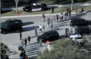  ?? MIKE STOCKER — SOUTH FLORIDA SUN-SENTINEL VIA AP ?? In this file photo, students hold their hands in the air as they are evacuated by police from Marjory Stoneman Douglas High School in Parkland, Fla., after a shooter opened fire on the campus.