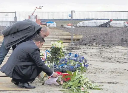  ?? Marcel Antonisse, AFP/Getty Images file ?? Two survivors of a 2009 Turkish Airlines crash place flowers as they attend a memorial ceremony at Amsterdam’s Schiphol Airport to honor the victims. Nine people were killed in the crash of the Boeing 737-800, en route from Istanbul to Amsterdam.