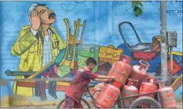  ?? ?? A worker domestic transports LPG gas cylinders through a tricycle cart, in Mumbai, on Thursday