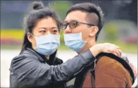  ?? REUTERS ?? A couple embrace each other while observing a flag raising ceremony at Chiang Kai Shek Memorial Hall n in Taipei, Taiwan on Wednesday.