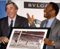  ?? FOTO: AP ?? Vede FIFA’s 100 års jubilæum i 2004 præsentere­r Pelé billedet af redningen fra VM i 1970 for Gordon Banks.