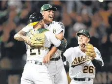  ?? /GETTY IMAGES ?? Sean Manaea (centro) es felicitado por Jonathan Lucroy y Matt Chapman (26) tras su hazaña ante Boston.