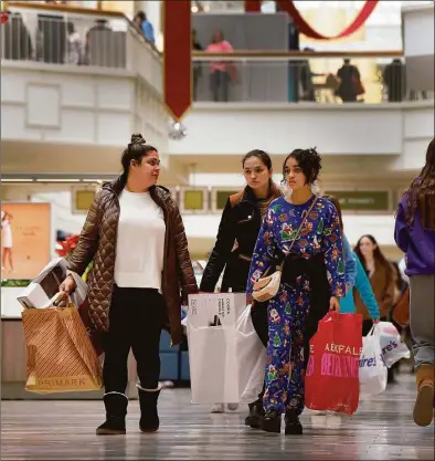  ?? Carol Kaliff / For Hearst Connecticu­t Media ?? From left, Aline Nunes of Danbury with Mary and Rebeca Jardy, visiting for the holiday, shop at the Danbury Fair mall on Black Friday.