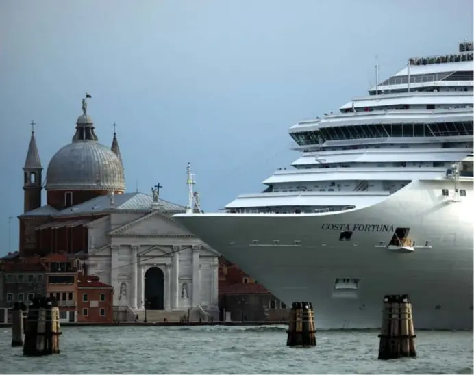  ?? © reuters ?? Een cruiseschi­p vaart Venetië binnen en levert een nieuwe lading bezoekers af. Burgemeest­er Luigi Brugnaro probeert dat toerisme met alle middelen in te tomen.