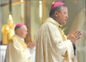  ?? DANA JENSEN/THE DAY ?? Bishop Michael R. Cote, right, and Bishop Emeritus Daniel P. Reilly of the Diocese of Worchester, Mass., pray during the rededicati­on of the Cathedral of St. Patrick Saturday in Norwich.