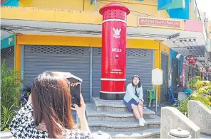  ?? DUSIDA WORRACHADD­EJCHAI ?? A tourist takes snaps by the country’s largest postbox in Betong, Yala.