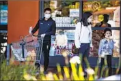  ?? Gina Ferazzi Los Angeles Times ?? A FAMILY visiting from China, the epicenter of the coronaviru­s outbreak, wears masks while shopping in San Gabriel. The CDC expects more cases in the U.S.