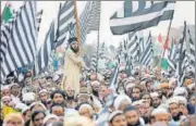  ?? REUTERS ?? A supporter of the party Jamiat Ulema-i-islam-fazal (JUI-F) holds a flag while others listen to a speech during a rally in Islamabad.