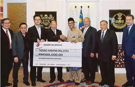  ?? PIC BY ABDULLAH YUSOF ?? Perak Menteri Besar Ahmad Faizal Azumu (fourth from right) accepting a donation for Tabung Harapan Malaysia from Unisem (M) Bhd chairman John Chia Sin Tet (fifth from right) in Ipoh yesterday.