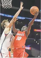  ?? MARK J. TERRILL ASSOCIATED PRESS ?? New Mexico forward Makuach Maluach, right, shoots against Saint Mary’s center Jordan Hunter on Friday at the Air Force Reserve Hall of Fame Classic in Los Angeles. The Lobos lost a second straight game in a blowout, 85-60.