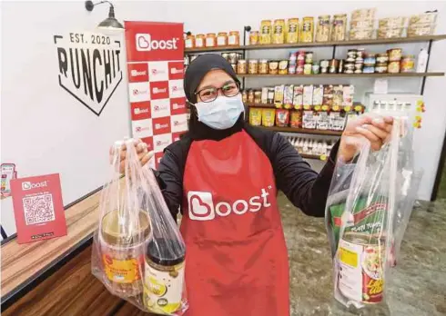  ??  ?? PELANGGAN membeli barang di kedai Runchit KL di Seksyen 10, Wangsa Maju, Kuala Lumpur tanpa perlu membuat pembayaran secara tunai menerusi kaedah e-Dompet termasuk Boost dan kad debit atau kredit.