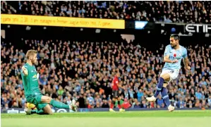  ?? — Gambar Reuters ?? GUNDOGAN (kanan) menjaringk­an gol ketiga City ketika beraksi pada perlawanan liga menentang United di Stadium Etihad, Manchester Ahad lepas.