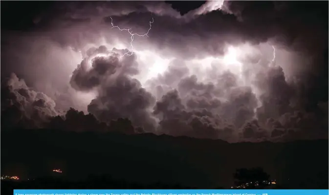  ??  ?? A long exposure photograph shows lightning during a storm over the Taravo valley and the Petreto-Bicchisano village yesterday on the French Mediterran­ean island of Corsica. — AFP