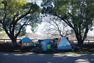  ?? PHOTOS BY RANDY VAZQUEZ — STAFF ARCHIVES ?? Tents are up near the orchard at Guadalupe River Park in San Jose on Feb. 2. A pilot clean-up program has been approved.