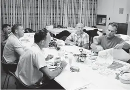  ?? HANDOUT/TNS ?? Apollo 11 astronauts Neil Armstrong, second from left, Michael Collins and Edwin “Buzz” Aldrin eat breakfast with Donald “Deke” Slayton, right, on launch day, July 16, 1969.