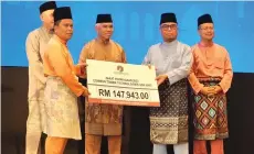 ?? ?? Yusof (third left) presenting a replica cheque to Yahya.