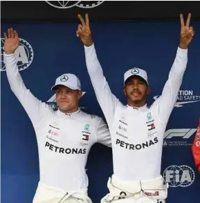  ?? AFP PIC ?? Mercedes AMG Petronas’ Lewis Hamilton (right) and Valtteri Bottas celebrate after grabbing pole and second spot after qualifying for the Hungarian Grand Prix yesterday.