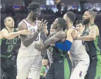  ?? MITCHELL LEFF/GETTY IMAGES ?? 76ers centre Joel Embiid, wearing a facemark, gets into an altercatio­n with the Celtics’ Terry Rozier, centre, on Monday.