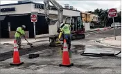  ?? KEVIN D. THOMPSON / THE PALM BEACH POST ?? Workers toil on a road in downtown Lake Worth on Monday afternoon.