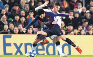  ?? PHOTO: GETTY IMAGES ?? Excuse me . . . Carles Alena, of FC Barcelona (front) tangles with Erik Lamela, of Tottenham Hotspur, during their drawn Uefa Champions League group B match at Camp Nou yesterday.
