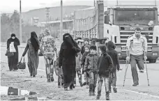  ?? CHRIS MCGRATH, GETTY IMAGES ?? People walk to a temporary housing complex near the border gate in Kilis, Turkey. “We are providing them with humanitari­an support,” said Deputy Prime Minister Numan Kurtulmus.