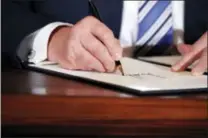  ?? THE ASSOCIATED PRESS ?? President Donald Trump signs a proclamati­on during a “Made in America,” product showcase Monday featuring items created in each of the U.S. 50 states, at the White House, in Washington.