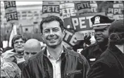  ??  ?? Mayor Pete Buttigieg, left, leads supporters on a walk Friday to the Democratic Party Liberty and Justice Dinner in Des Moines. Sen. Kamala Harris speaks Friday in Des Moines.