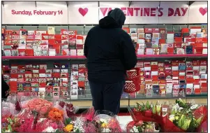  ?? (AP/Charles Rex Arbogast) ?? A shopper at a Chicago-area store browses through the Valentine’s Day cards Saturday.