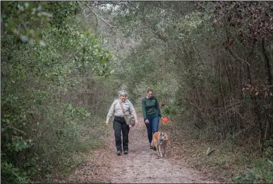  ??  ?? Suzi Goodhope, a cadaver dog handler, with Victoria Cacchione and Shiraz, search for a suspected American Indian burial site in Gulf Breeze, Fla., in February. Recent research highlights the power of the canine nose to uncover buried remains from ancient human history.
(The New York Times/Emily Kask)