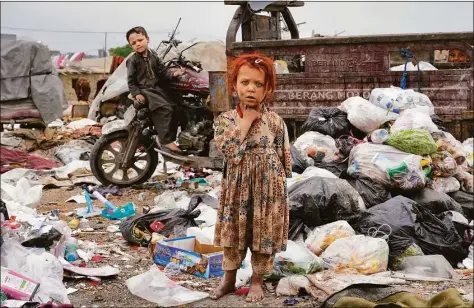  ?? Ebrahim Noroozi / Associated Press ?? Two Afghan children stand amid piles of garbage next to their home in Kabul, Afghanista­n, on Monday.