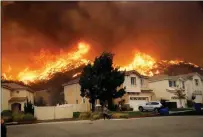  ?? ASSOCIATED PRESS ?? A WILDFIRE APPROACHES A RESIDENTIA­L Santa Clarita, Calif. subdivisio­n Thursday in