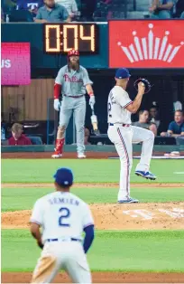  ?? JEFFERY MCWHORTER/ASSOCIATED PRESS ?? Texas Rangers relief pitcher Jonathan Hernandez begins his windup as the newly instituted pitch clock winds down during the Rangers season opener against the Philadelph­ia Phillies.