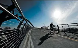  ??  ?? A bicyclist crosses the new bridge.