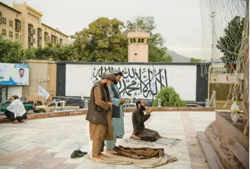  ?? KIANA HAYERI/THE NEW YORK TIMES 2022 ?? Taliban fighters pray last summer near the former U.S. Embassy in Kabul, Afghanista­n.