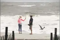  ?? Andrew Knapp / Associated Press ?? Lynn Williams, left, and Guy Covington watch the surf from Tropical Storm Florence as the storm pulled away from Myrtle Beach, N. C., on Saturday.