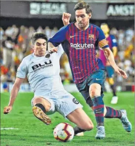  ?? AFP ?? ▪ Valencia midfielder Carlos Soler tackles Barcelona's Lionel Messi during their match on Sunday.