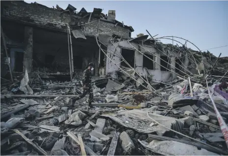  ?? AP ?? An Azeri soldier walks among destroyed houses in Ganja, yesterday. Azerbaijan said Armenia hit the city with a ballistic missile