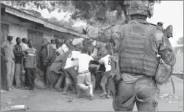  ?? JEROME DELAY/ THE ASSOCIATED PRESS ?? A French soldier yells at a mob of Christians attacking possible Muslim rebels before firing warning shots Monday in Bangui, Central African Republic. Both Christian and Muslim mobs went on lynching sprees as French forces deployed in the capital.