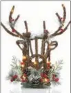  ?? MACY’S VIA AP ?? Fairy lights and snow-encrusted seasonal elements dressing up a deer’s head vine and berry table decoration from the Martha Stewart Collection at Macy’s.