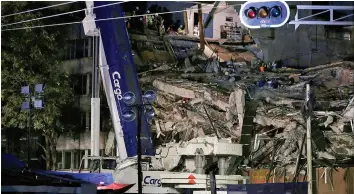  ??  ?? Members of rescue teams work in the rubble of a collapsed building. — Reuters photo