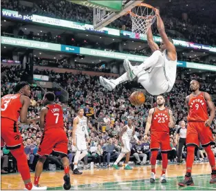  ?? AP PHOTO ?? Boston Celtics’ Al Horford hangs from the rim after dunking as Toronto Raptors’ Fred Vanvleet (23) and Serge Ibaka (9) look on during the fourth quarter of an NBA game in Boston on Sunday.