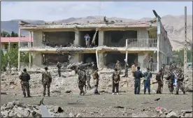  ?? (AP) ?? Security personnel inspect the site of a car bombing Monday at an intelligen­ce complex in Aybak, Afghanista­n. The bombing opened the way for Taliban fighters to enter the complex, where they engaged Afghan forces in an hourslong battle that left several people dead.
