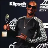  ??  ?? Snoop Dogg poses with an award given posthumous­ly to Tupac Shakur.